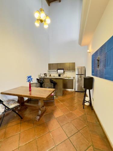 a large kitchen with a wooden table in a room at El Calvario Lofts in Antigua Guatemala