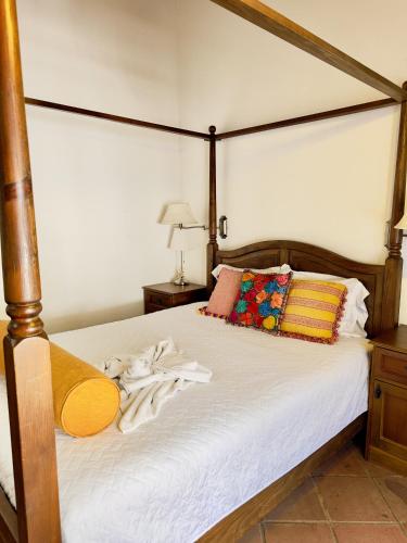 a bedroom with a bed with white sheets and pillows at El Calvario Lofts in Antigua Guatemala