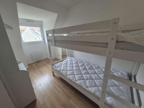 une chambre avec deux lits superposés et une fenêtre dans l'établissement Charmante maison de plage à Merlimont - 6 personnes, terrasse et WIFI - FR-1-672-39, à Merlimont