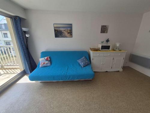 un canapé bleu dans une pièce avec une fenêtre dans l'établissement Appartement proche plage avec parking et wifi - 4 personnes - FR-1-672-38, à Merlimont