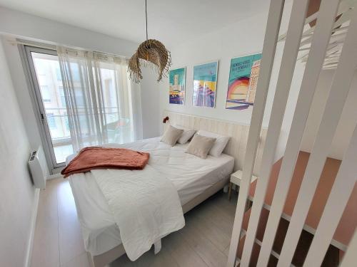 une chambre avec un lit blanc et une grande fenêtre dans l'établissement Appartement Neuf Proche Plage avec WiFi - FR-1-92-952, à Les Sables-dʼOlonne