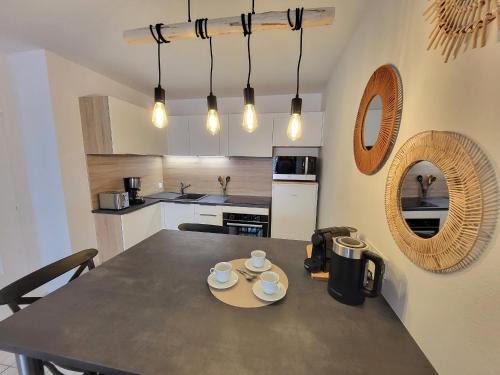 - une cuisine avec une table et deux tasses dans l'établissement Appartement Neuf Proche Plage avec WiFi - FR-1-92-952, à Les Sables-dʼOlonne