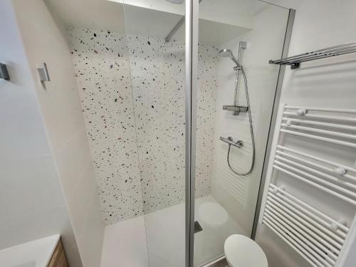 une douche avec une porte vitrée dans une salle de bain dans l'établissement Appartement Neuf Proche Plage avec WiFi - FR-1-92-952, à Les Sables-dʼOlonne