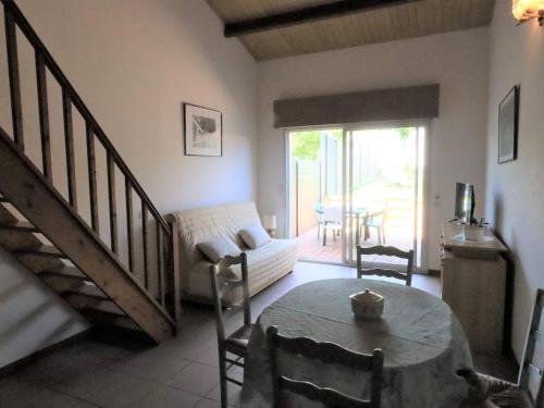 un salon avec une table et un canapé dans l'établissement Maison rénovée 1 étoile avec jardin, 4 couchages - FR-1-738-49, à Saint-Georges-de-Didonne