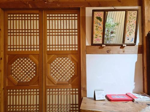 a room with a wooden wall with two books on a table at Haenggung stay Dalno - Suwon private house hanok in Suwon