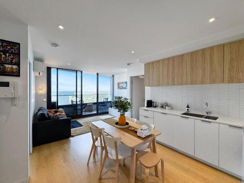 a kitchen and living room with a table and chairs at Ocean View Modern 2 bedroom with Parking in St Kilda in Melbourne