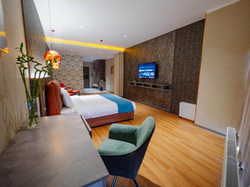 a hotel room with a bed and a tv on a wall at Bojon Hotel Ulaanbaatar - Soyolj Mall in Ulaanbaatar