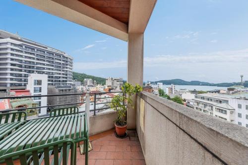 a balcony with two green benches on a building at Sun Moon Lake ItaThao Vacation Inn with Elevator in Yuchi