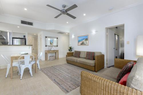 a living room with a couch and a table at Mandalay Luxury Beachfront Apartments in Port Douglas