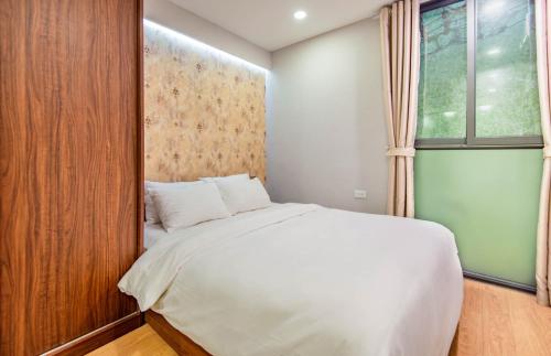 a bedroom with a white bed and a window at 22Land Moon West Lake in Hanoi
