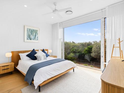 Baja on Cylinders - Beachfront Bliss في كينغسكليف: غرفة نوم بها سرير ونافذة كبيرة