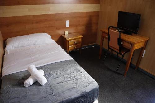 a bedroom with a bed with a teddy bear on it at Hotel Don Jose in Puertollano
