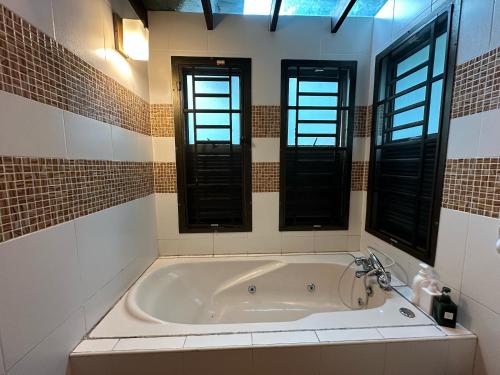 a bath tub in a bathroom with two windows at JB home Mount Austin SemiD near Toppen IKEA Aeon fix to 14pax in Johor Bahru