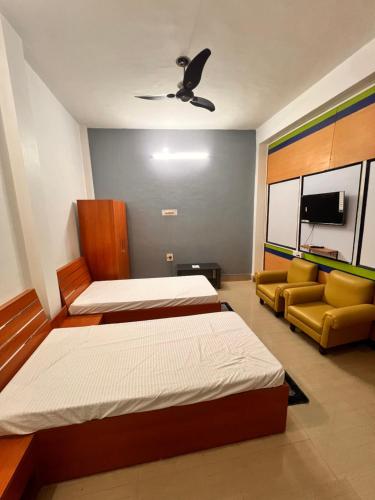 a bedroom with two beds and a couch at Shri Shyam Kunj in Ayodhya