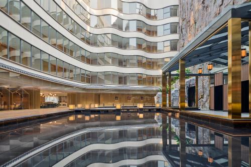 a swimming pool in front of a building at Hilton Garden Inn Foshan Lishui-Free Shuttle Bus for Canton Fair in Foshan