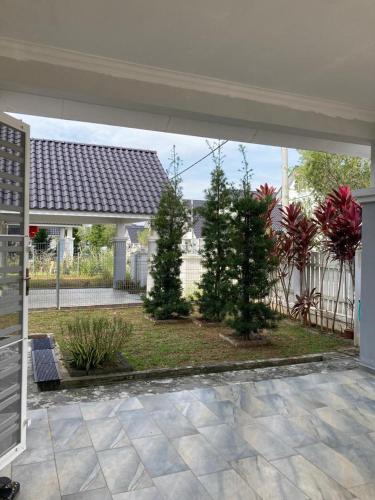 an empty patio with trees and a fence at Mstaycation in Kampong Ayer Panas