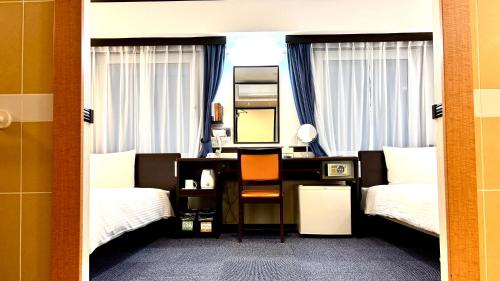 a bedroom with two beds and a desk with a mirror at Toyoko Inn Chiba Shin kamagaya Ekimae in Kamagaya