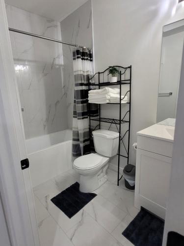 a white bathroom with a toilet and a shower at Elegant & Cozy 2 Bdrm Basement suite near WEM in Edmonton