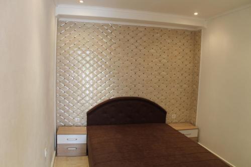 a bed in a room with a wall at Rooms and Apartments Milana in Bar