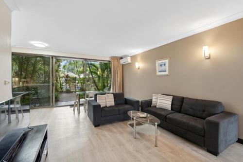 a living room with a couch and a table at Smugglers On The Beach in Coffs Harbour