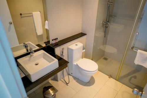 a bathroom with a toilet and a sink and a shower at Oceanfront Galle by ICC in Galle