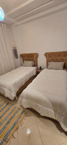 two beds sitting next to each other in a room at Résidence achakkar hill in Jbila