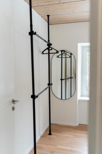 a round mirror on a black pole in a room at homy Alpenlodge in Innerbraz