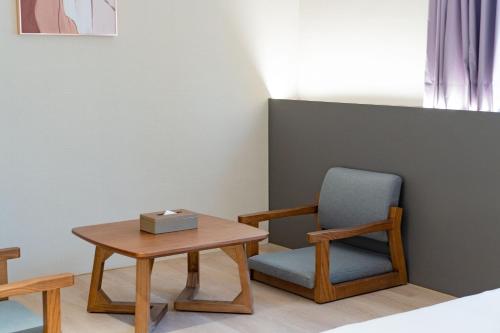 a room with a table and a chair at Talmud Hotel Classic Taiwan Boulevard in Taichung