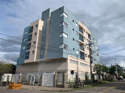 カシアス・ド・スルにあるApartamento Dois quartos e duas vagas garagem fechadasの駐車場前の高層アパートメントビル