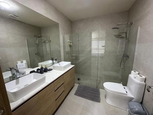 a bathroom with two sinks and a shower and a toilet at Apartamento Playa Escondida in María Chiquita