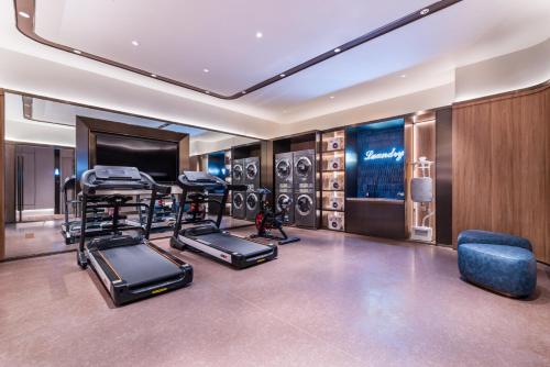 a room with a gym with exercise equipment and a television at 杭州萧山建设三路桔子水晶酒店 in Hangzhou