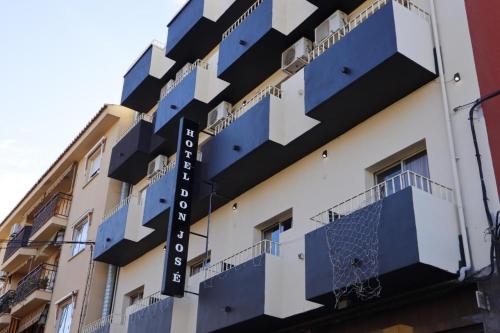 a building with blue balconies on the side of it at Hotel Don Jose in Puertollano