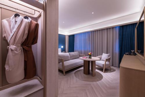 a room with a living room with a couch and a table at 杭州萧山建设三路桔子水晶酒店 in Hangzhou