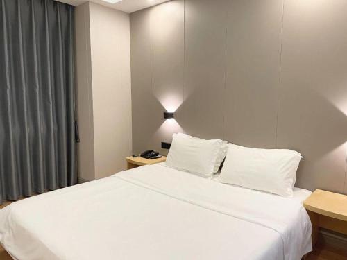 Postel nebo postele na pokoji v ubytování 7 Days Inn Fucheng Wu Gongci Gaodeng East Street Binjiang Road
