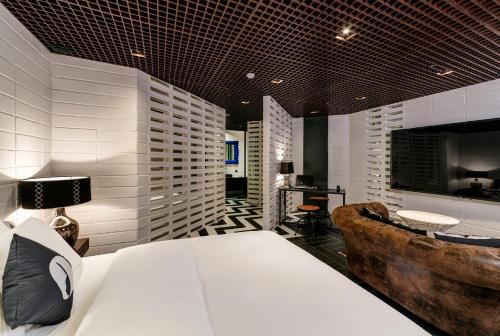 a bedroom with a bed and a tv and a couch at Hotel The Designers Cheongnyangni in Seoul