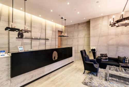 a hotel lobby with a reception desk and chairs at Hotel The Designers Cheongnyangni in Seoul