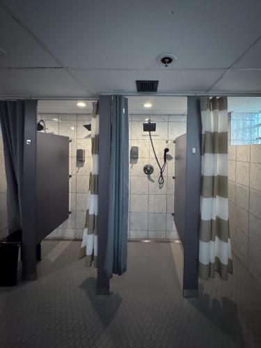 a bathroom with a shower with blue and white curtains at U Street Capsule Hostel in Washington