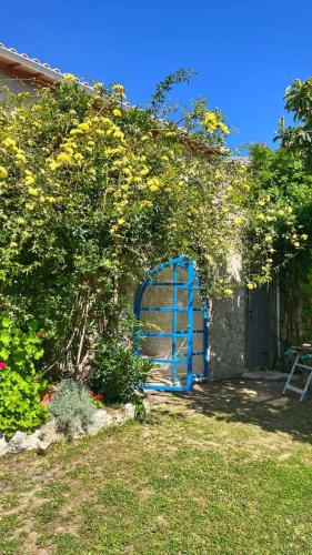 a blue gate in front of a building with flowers at Villa Bakola in Sívros