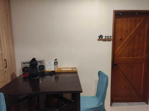 a desk with a blue chair and a wooden door at 一個人背包客棧 in Wujie