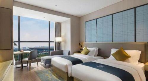 a hotel room with two beds and a large window at Echarm Hotel Changsha High-speed Railway Station in Changsha