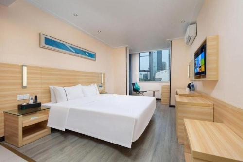 a large white bed in a hotel room at City Comfort Inn Wuhan Zhongnan Road Fujiaopo in Wuhan