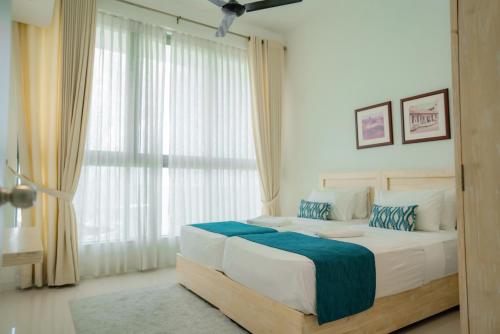 a bedroom with a large bed and a large window at Oceanfront Galle by ICC in Galle