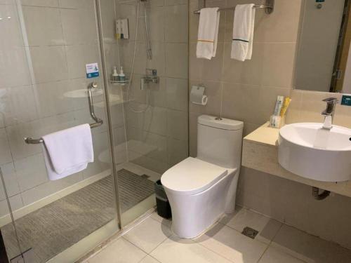 a bathroom with a shower and a toilet and a sink at City Comfort Inn Yichang Dongshan Three Gorges University Shuiyuecheng in Yichang