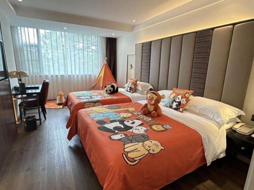 two beds in a hotel room with stuffed animals on them at Jinjiang Metropolo Haikou East High Speed Railway Station Normal University in Haikou