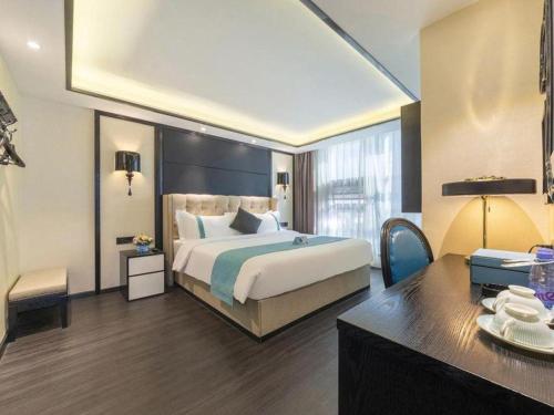 a hotel room with a bed and a desk at Xana Hotelle Nanchang Tengwang Pavilion Wanshougong in Nanchang