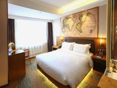 a hotel room with a large bed and a desk at James Joyce Coffetel Changchun People's Square in Changchun