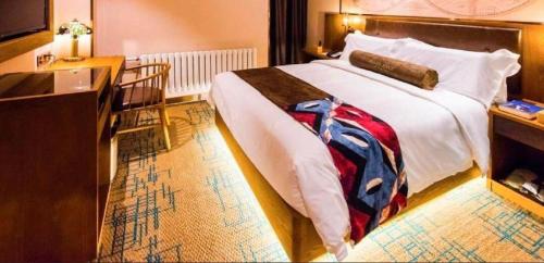 a bedroom with a large bed and a dresser at James Joyce Coffetel Changchun People's Square in Changchun