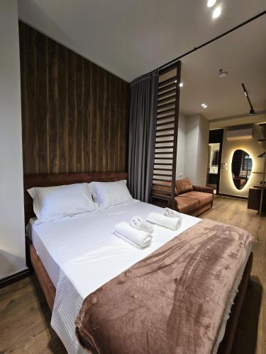 a bedroom with a large bed with two towels on it at SOLs Center Rooms in Tirana