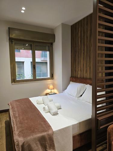 a bedroom with a large bed with towels on it at SOLs Center Rooms in Tirana