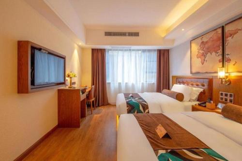 a hotel room with two beds and a television at James Joyce Coffetel Kunming Railway Station Huancheng Nan Road Metro Station in Kunming
